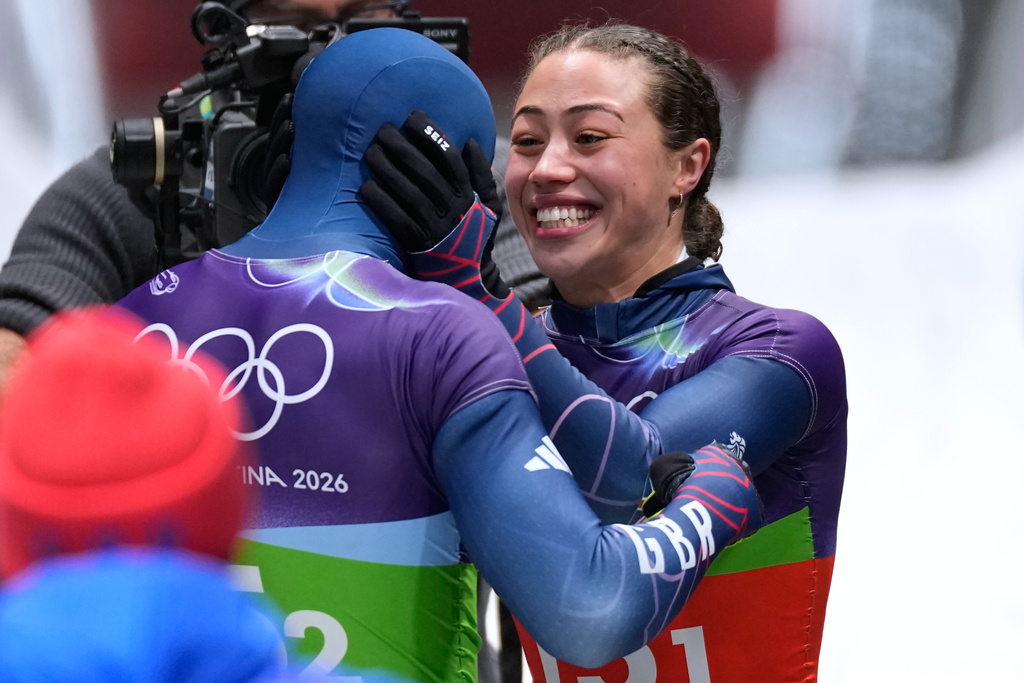 Britain's gold medalists Matt Weston, left, and Britain's Tabitha Stoecker, right, celebrate at the finish during the skeleton mixed team competition at the 2026 Winter Olympics, in Cortina d'Ampezzo, Italy, Sunday, Feb. 15, 2026. (AP Photo/Aijaz Rahi)