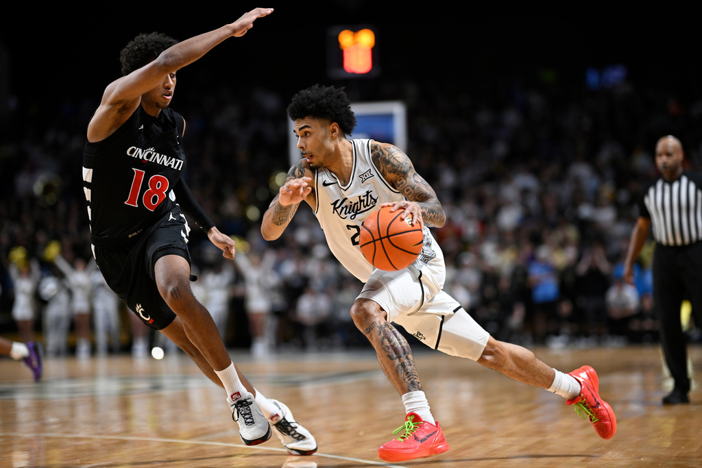 Central Florida guard Chris Johnson, right, drives to the basket as Cincinnati forward Baba Miller (18) defends during the second half of an NCAA college basketball game, Sunday, Jan. 11, 2026, in Orlando, Fla. (AP Photo/Phelan M. Ebenhack)