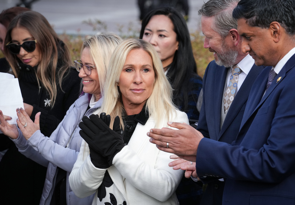 Rep. Marjorie Taylor-Greene, R-Ga., center, with Rep. Thomas Massie, R-Ky., second from right, and Rep. Ro Khanna, D-Calif., far right, applauds during a news conference as the House prepares to vote on the Epstein Files Transparency Act, at the Capitol in Washington, Tuesday, Nov. 18, 2025. (AP Photo/J. Scott Applewhite)