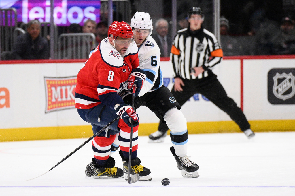 Utah Mammoth defenseman John Marino (6) battles for the puck against Washington Capitals left wing Alex Ovechkin (8) during the second period of an NHL hockey game, Tuesday, March 3, 2026, in Washington. (AP Photo/Nick Wass)