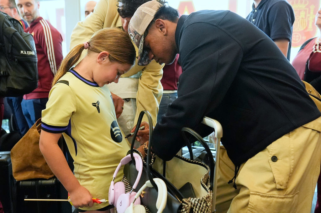 Spain midfielder Lamine Yamal, right, signs an autograph for Griffin Wamp, left, after arriving with teammates for the World Cup soccer tournament Friday, June 5, 2026, in Chattanooga, Tenn. (AP Photo/George Walker IV)
