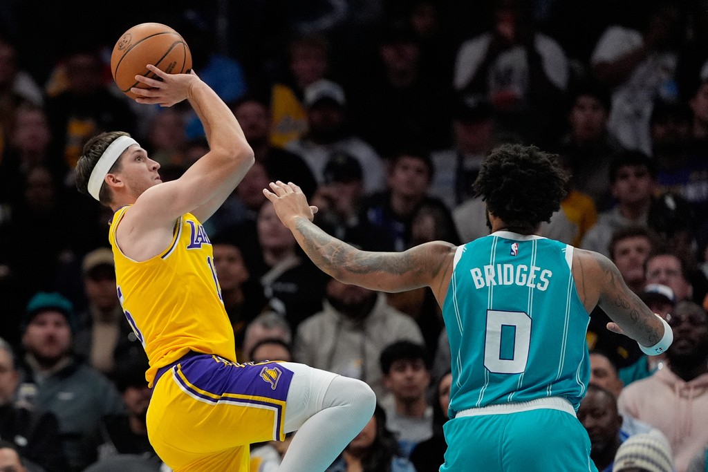 Los Angeles Lakers guard Austin Reaves shoots over Charlotte Hornets forward Miles Bridges during the first half of an NBA basketball game Monday, Nov. 10, 2025, in Charlotte, N.C. (AP Photo/Chris Carlson)