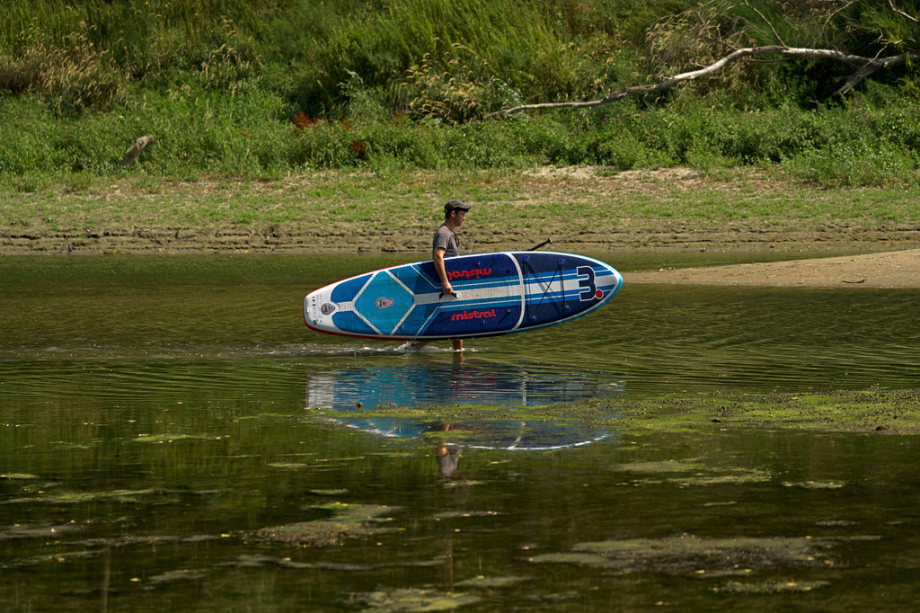 People walk on sandbanks exposed by record-low water levels in the Danube River after drought and extreme heat near Nagymaros, Hungary, Tuesday, on Aug. 18, 2026. (AP Photo/Bela Szandelszky)