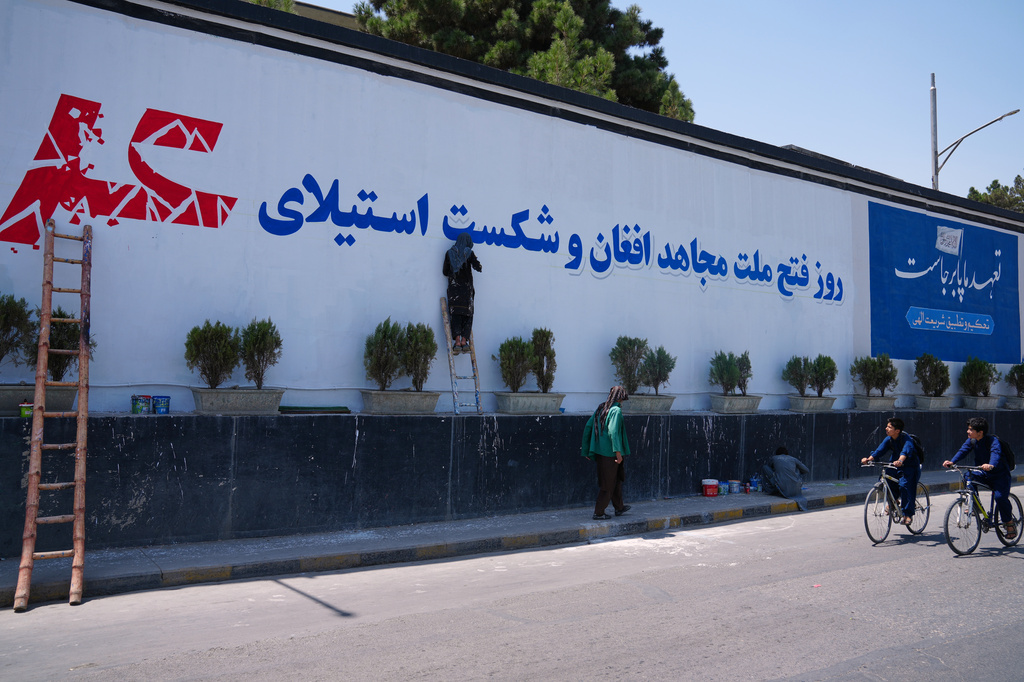 Workers paint a mural celebrating the Taliban's victory and the defeat of the U.S.-led occupation ahead of celebrations marking five years of Taliban rule, in Kabul, Afghanistan, Thursday, Aug. 13, 2026. (AP Photo/Siddiqullah Alizai)