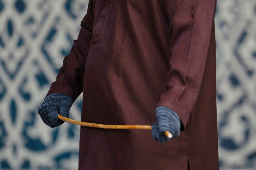A shariah law official holds a rattan cane before the public caning of a young couple after an Islamic Shariah court convicted them of violating Islamic law by kissing during a TikTok livestream, in Banda Aceh, Indonesia, Thursday, July 2, 2026. (AP Photo/Reza Saifullah)