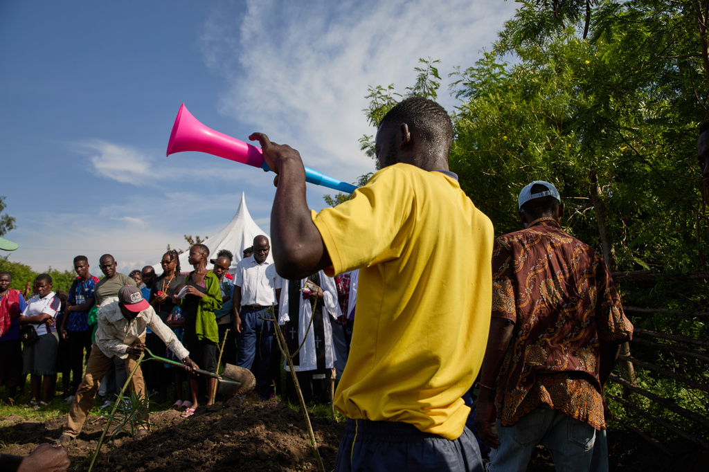 Family and friends shovel dirt onto the coffin of Tom Ochieng Mima on the outskirts of Kisumu, Kenya, Friday, March 13, 2026. (AP Photo/Asa Wallin)