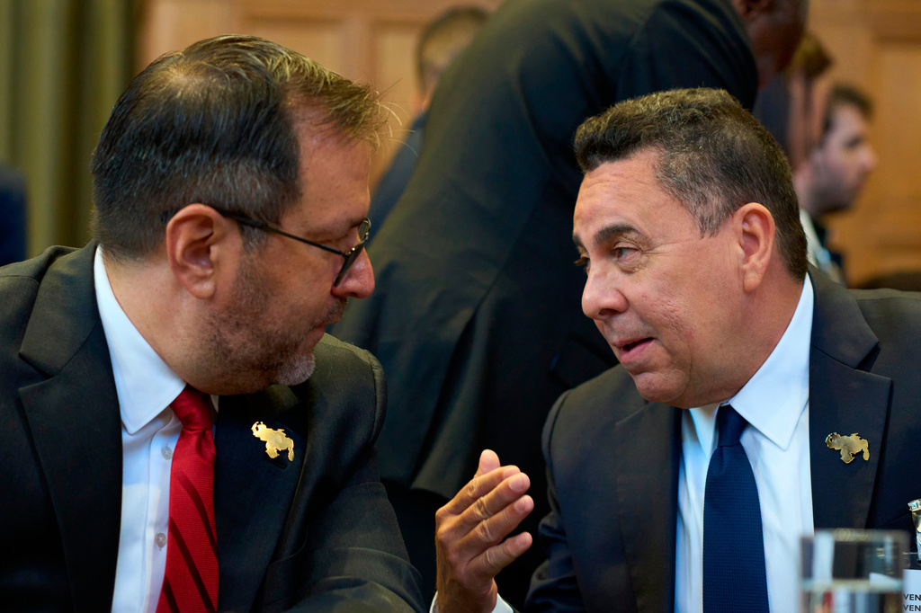 Samuel Reinaldo Moncada Acosta, right, speaks to Venezuela's Foreign Affairs minister Yvan Gil Pinto as the International Court of Justice opens a week of hearings in a border dispute dating back to the end of the 19th century between Guyana and Venezuela, in The Hague, Netherlands, Monday, May 4, 2026. (AP Photo/Peter Dejong)