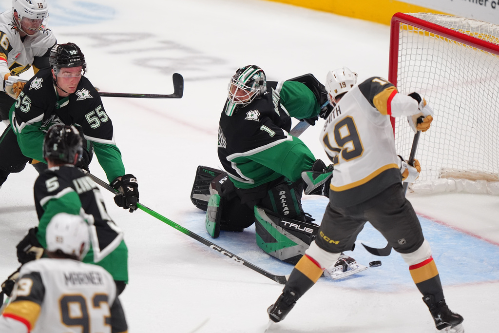 Vegas Golden Knights right wing Reilly Smith (19) scores a goal against Dallas Stars goaltender Casey DeSmith (1) and defenseman Thomas Harley (55) during the third period of an NHL hockey game Sunday, March 22, 2026, in Dallas. (AP Photo/LM Otero)
