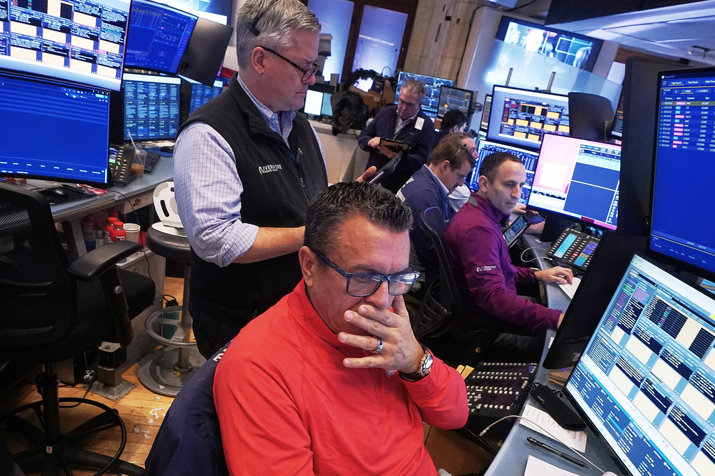 Trader Robert Finnerty Jr., foreground, works with colleagues on the floor of the New York Stock Exchange, Monday, Jan. 12, 2026. (AP Photo/Richard Drew)