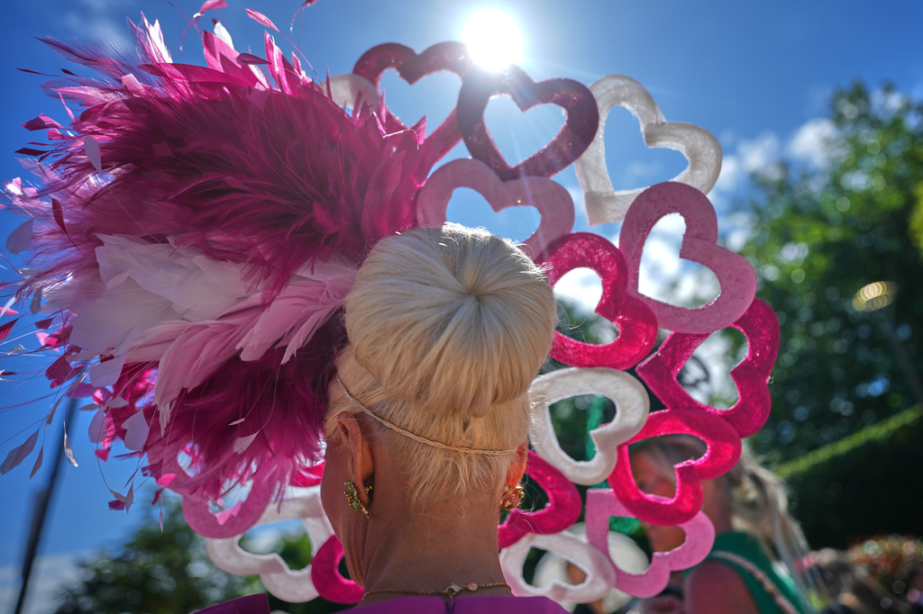 A racegoer wears a heart shaped hat as she arrives on the second day of the Royal Ascot horse race meeting in Ascot, England, Wednesday, June 17, 2026.(AP Photo/Alastair Grant)