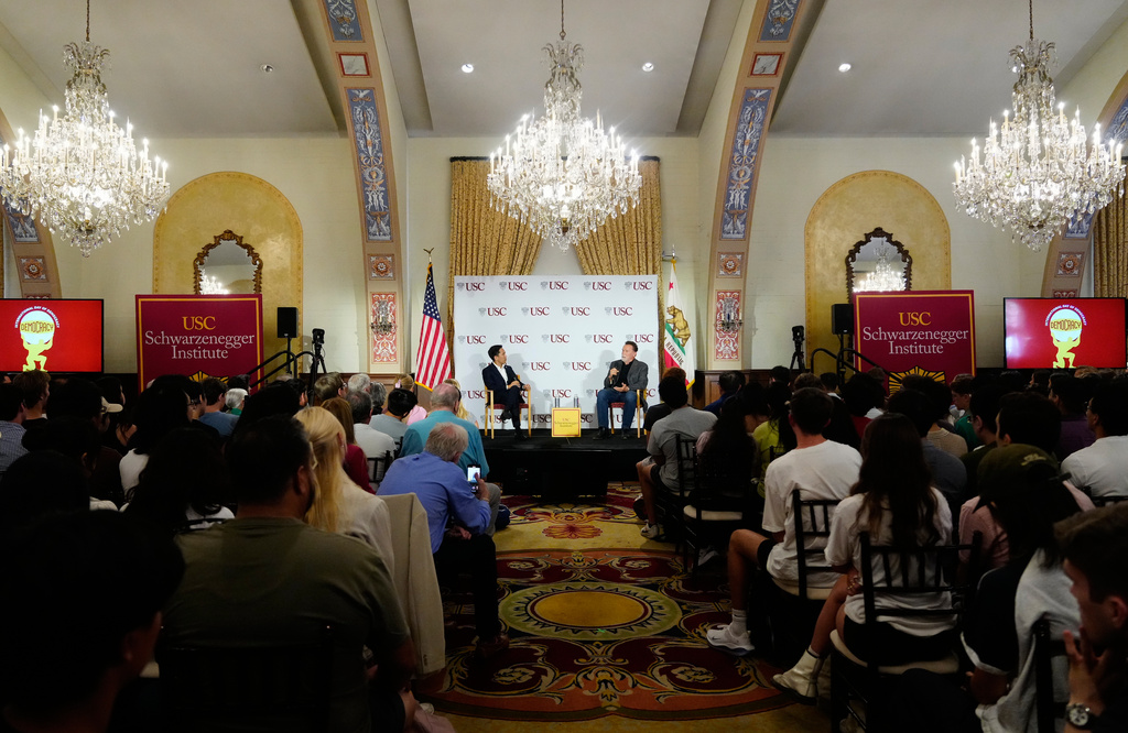 Former California Gov. Arnold Schwarzenegger, right, expresses his opposition to Proposition 50, a California ballot measure to redraw U.S. House maps to boost Democrats, during a conversation with University of Southern California interim president Beong-Soo Kim, left, on democracy at the USC campus in Los Angeles, Monday, Sept. 15, 2025. (AP Photo/Damian Dovarganes)