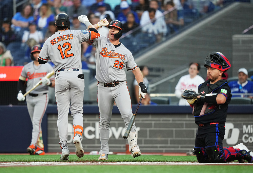 Baltimore Orioles' Dylan Beavers (12) celebrates his solo home run with Pete Alonso (25) as Toronto Blue Jays catcher Alejandro Kirk (30) looks on during the first inning of a baseball game in Toronto on Friday, Sept. 11, 2026. (Nathan Denette/The Canadian Press via AP)