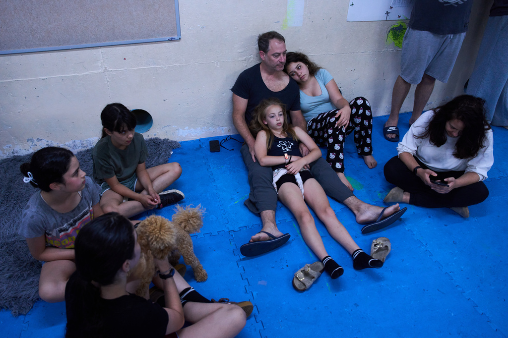 People take shelter as air raid sirens warn of incoming Iranian missiles in Ramat Gan, Israel, Monday, June 8, 2026. (AP Photo/Oded Balilty)