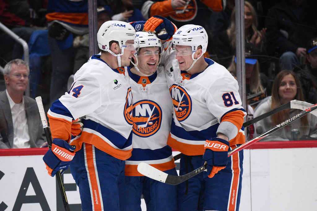 New York Islanders center Mathew Barzal, center, celebrates after his goal with center Bo Horvat (14) and left wing Ondrej Palat (81) during the first period of an NHL hockey game against the Washington Capitals, Monday, Feb. 2, 2026, in Washington. (AP Photo/Nick Wass)
