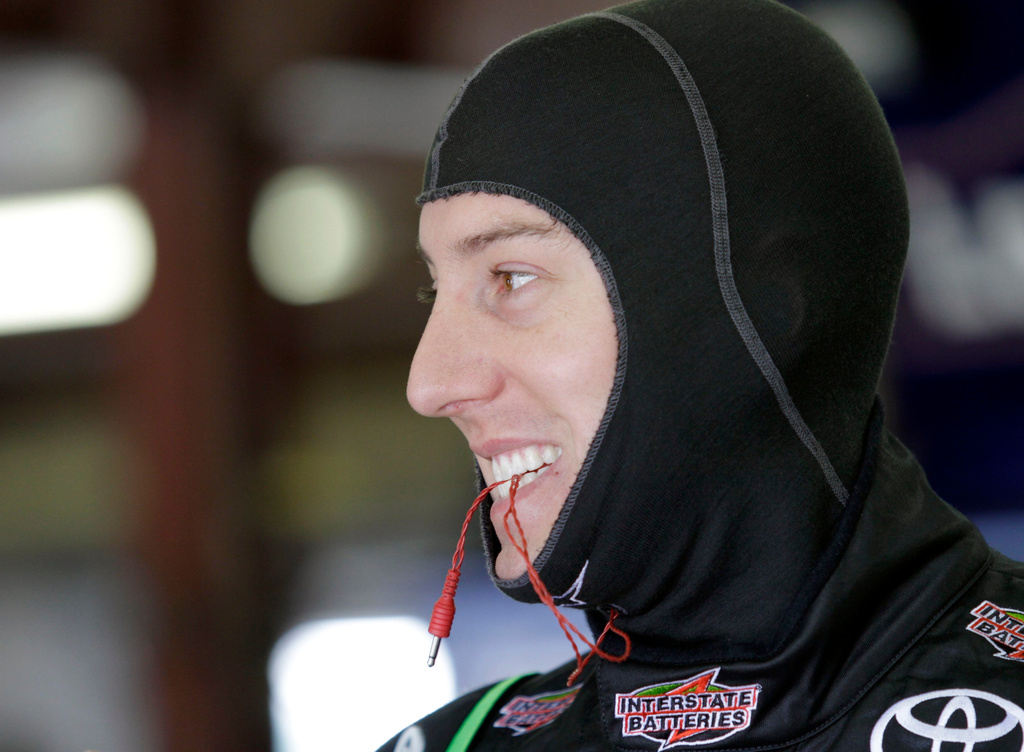 FILE - NASCAR driver Kyle Busch bites his earpiece cord as he gets ready to practice for the NASCAR Lenox Industrial Tools 301auto race at New Hampshire Motor Speedway in Loudon, N.H., Friday, July 15, 2011. (AP Photo/Mary Schwalm, File)