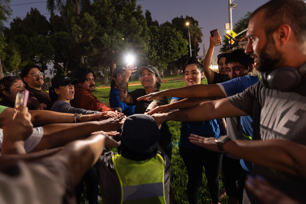 Iris Delgado, center, founder of the Huntington Park Run Club, leads a huddle after their run in Huntington Park, Calif., Sept. 24, 2025. (AP Photo/Jae C. Hong)