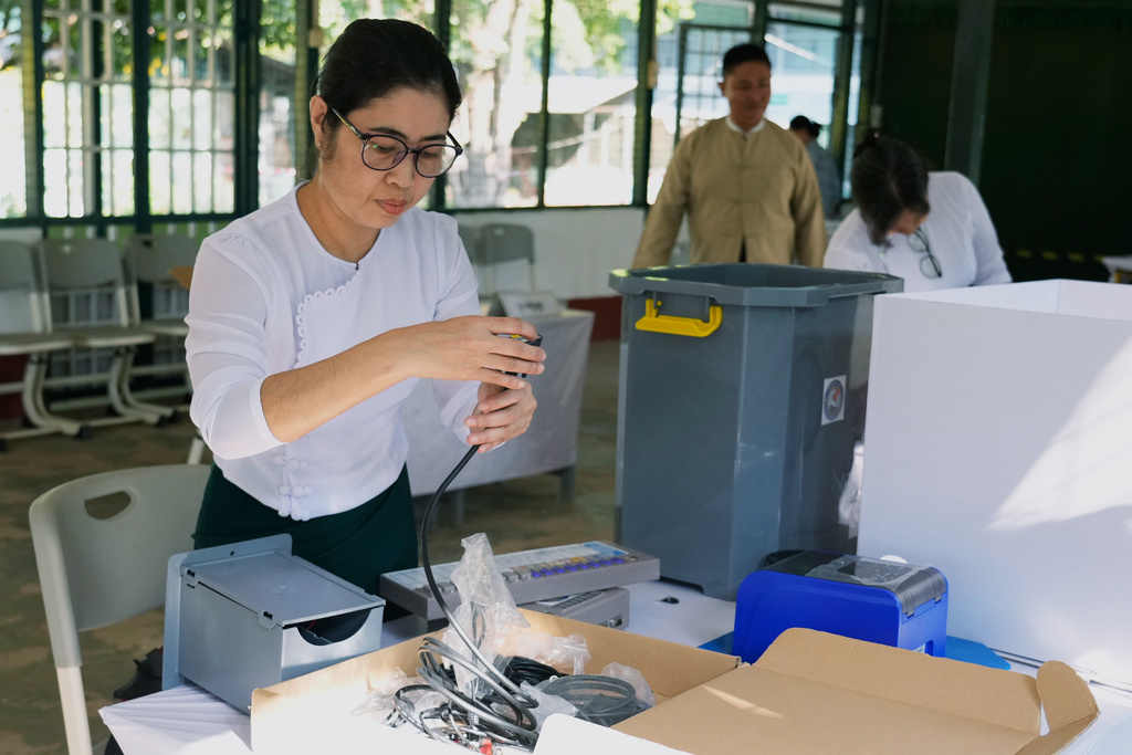 An official of the Union Election Commission sets up an electronic voting machine at a polling station, one day ahead of the third phase of the general election, in Yangon, Myanmar, Saturday, Jan. 24, 2026. (AP Photo/Thein Zaw)