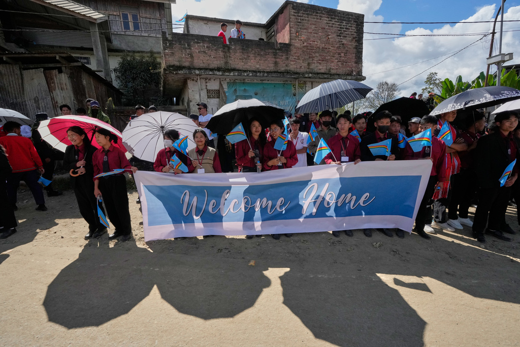 People hold the Naga flag and wait to greet Thuingaleng Muivah, leader of the National Socialist Council of Nagaland (Isak-Muivah), in Ukhrul, in the northeastern Indian state of Manipur, Wednesday, Oct. 22, 2025. (AP Photo/Anupam Nath)