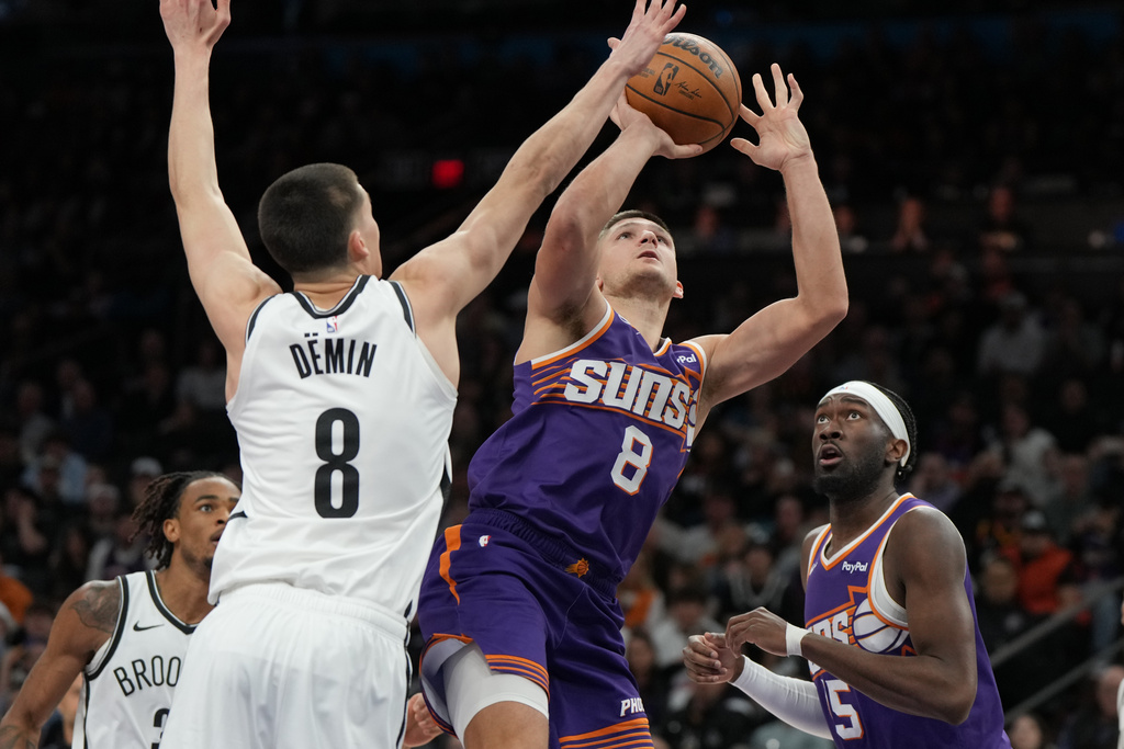 Phoenix Suns guard Grayson Allen (8) shoots on Brooklyn Nets guard Egor Demin (8) during the second half of an NBA basketball game, Tuesday, Jan. 27, 2026, in Phoenix. (AP Photo/Rick Scuteri)