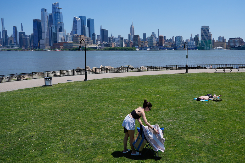 People lay out in the sun in front of the New York City skyline in Hoboken, N.J., Wednesday, May 20, 2026. (AP Photo/Seth Wenig)