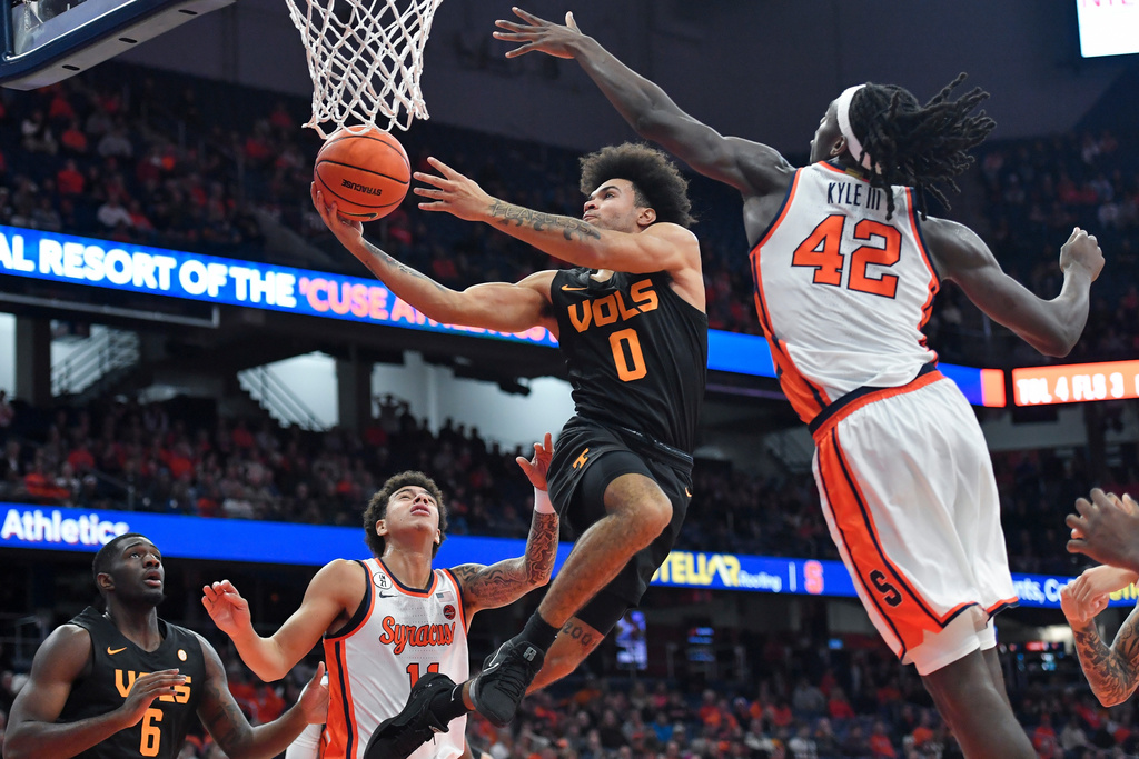 Tennessee guard Ja'Kobi Gillespie (0) drives to the basket between Syracuse forward William Kyle III (42) and guard Naithan George (11) during the first half of an NCAA college basketball game Tuesday, Dec. 2, 2025, in Syracuse, N.Y. (AP Photo/Adrian Kraus)