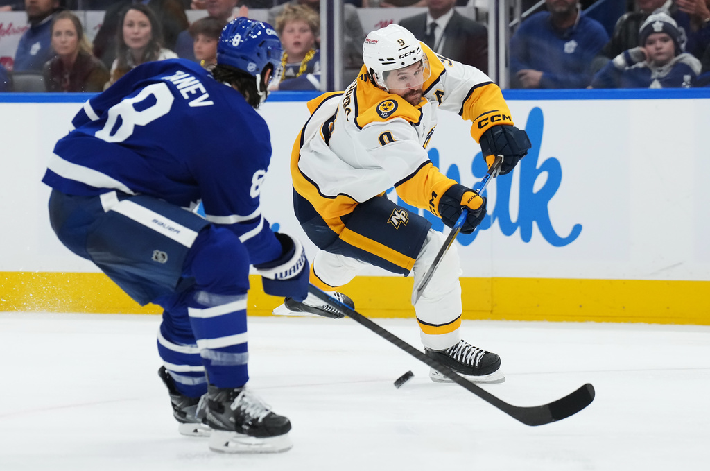 Nashville Predators' Filip Forsberg (9) shoots past Toronto Maple Leafs' Chris Tanev (8) during third period NHL hockey action in Toronto on Tuesday, October 14, 2025. (Nathan Denette/The Canadian Press via AP)