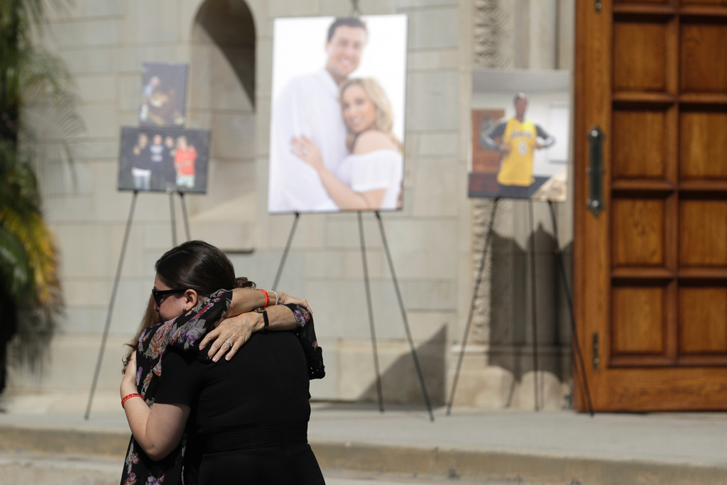 FILE - Mourners embrace during a memorial for Los Angeles Angels pitcher Tyler Skaggs at the St. Monica Catholic Church, July 22, 2019, in Los Angeles. (AP Photo/Marcio Jose Sanchez, File)