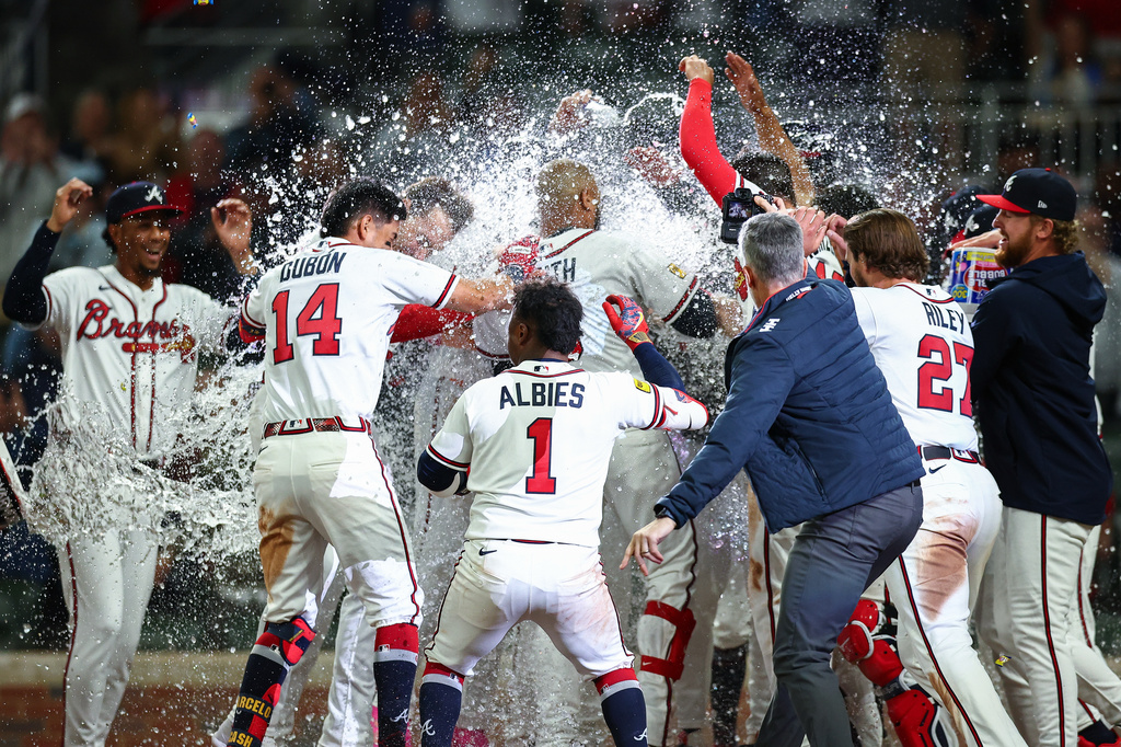 The Atlanta Braves celebrate at home plate after a walk-off grand slam from Dominic Smith, center, in the ninth inning of a baseball game against the Kansas City Royals, Saturday, March 28, 2026, in Atlanta. (AP Photo/Colin Hubbard)