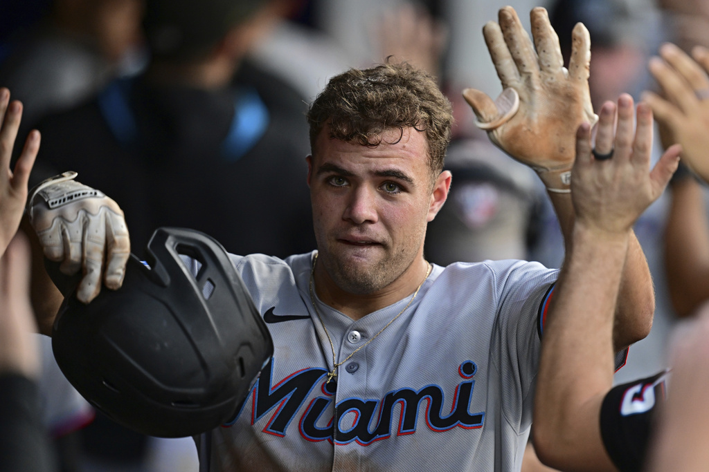 Miami Marlins' Jakob Marsee is congratulated in the dugout after hitting a two-run home run off Cleveland Guardians relief pitcher Matt Festa during the fifth inning of a baseball game, Wednesday, Aug. 13, 2025, in Cleveland. (AP Photo/David Dermer)
