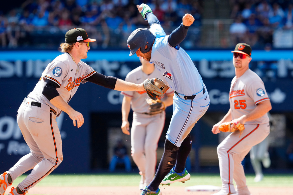 Toronto Blue Jays' George Springer, right, dodges the tag from Baltimore Orioles shortstop Gunnar Henderson (2) during a rundown in the fourth inning of a baseball game, Saturday, June 6, 2026, in Toronto. (Frank Gunn/The Canadian Press via AP)
