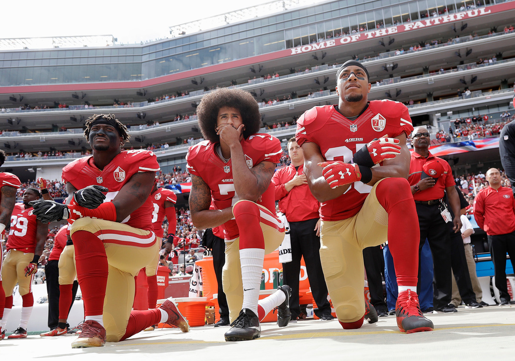 FILE - In this Oct. 2, 2016, file photo, from left, San Francisco 49ers outside linebacker Eli Harold, quarterback Colin Kaepernick and safety Eric Reid kneel during the national anthem before an NFL football game against the Dallas Cowboys in Santa Clara, Calif. (AP Photo/Marcio Jose Sanchez, File)