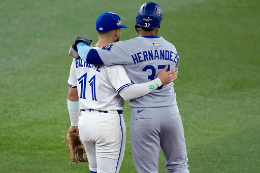 Los Angeles Dodgers' Teoscar Hernández (37) hugs Toronto Blue Jays' Bo Bichette during the second inning in Game 1 of baseball's World Series, Friday, Oct. 24, 2025, in Toronto. (AP Photo/David J. Phillip) Los Angeles Dodgers' Teoscar Hernández (37) hugs Toronto Blue Jays' Bo Bichette during the second inning in Game 1 of baseball's World Series, Friday, Oct. 24, 2025, in Toronto. (AP Photo/David J. Phillip)