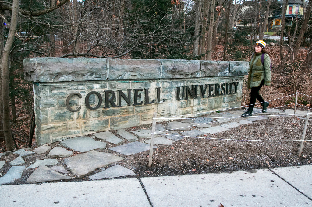 FILE - A woman walks by a Cornell University sign on the Ivy League school's campus in Ithaca, New York, Jan. 14, 2022. (AP Photo/Ted Shaffrey, File)