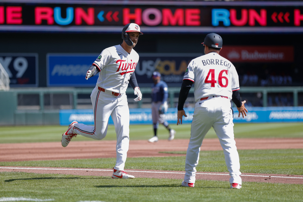 Minnesota Twins' Matt Wallner celebrates with third base coach Ramon Borrego (46) after hitting a solo home run during the second inning of a baseball game against the Tampa Bay Rays, Sunday, April 5, 2026, in Minneapolis. (AP Photo/Bailey Hillesheim)
