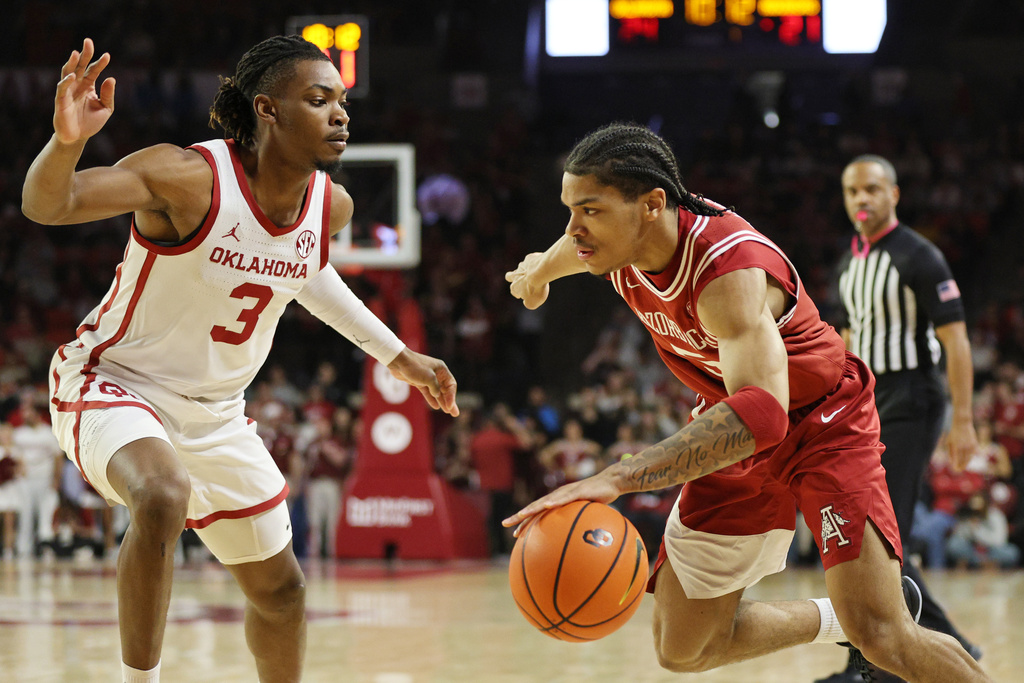 Arkansas guard Darius Acuff Jr., right, drives against Oklahoma guard Jeff Nwankwo (3) during the first half of an NCAA college basketball game Tuesday, Jan. 27, 2026, in Norman, Okla. (AP Photo/Nate Billings)