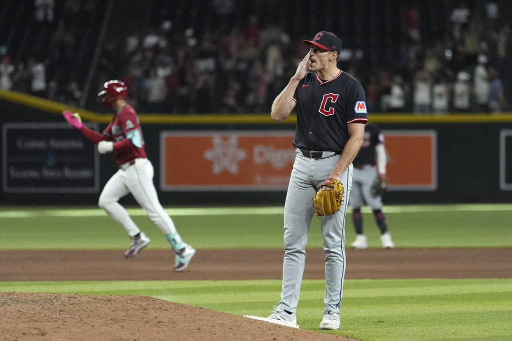 Cleveland Guardians pitcher Cade Smith, right, pauses behind the pitcher's mound after giving up a home run to Arizona Diamondbacks' Lourdes Gurriel Jr., left, during the ninth inning of a baseball game Wednesday, Aug. 20, 2025, in Phoenix. (AP Photo/Ross D. Franklin)
