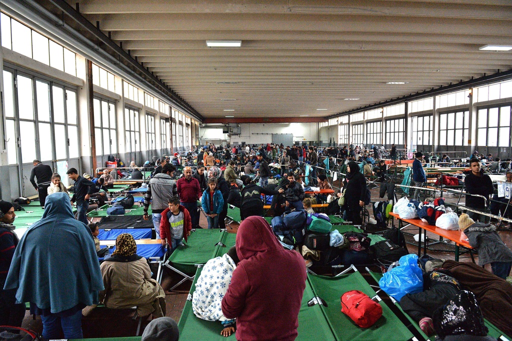 FILE - Refugees wait in a crowded migrant registration center in Passau, southern Germany, Oct. 8, 2015. (AP Photo/Kerstin Joensson, File)