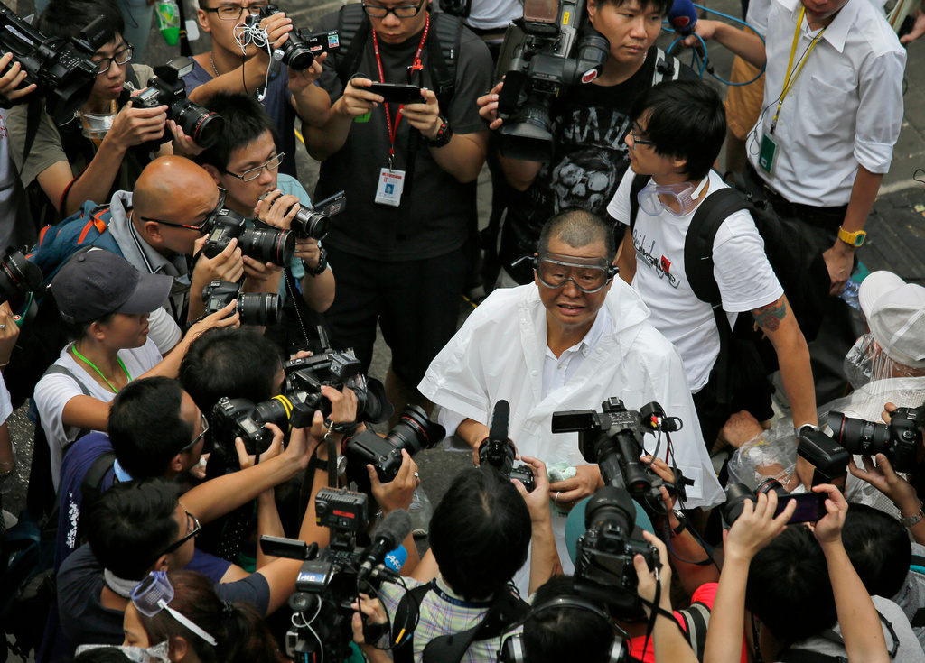FILE - Media mogul Jimmy Lai wearing goggles appears outside government headquarters to join a protest in Hong Kong, Sept. 28, 2014. (AP Photo/Vincent Yu, File)