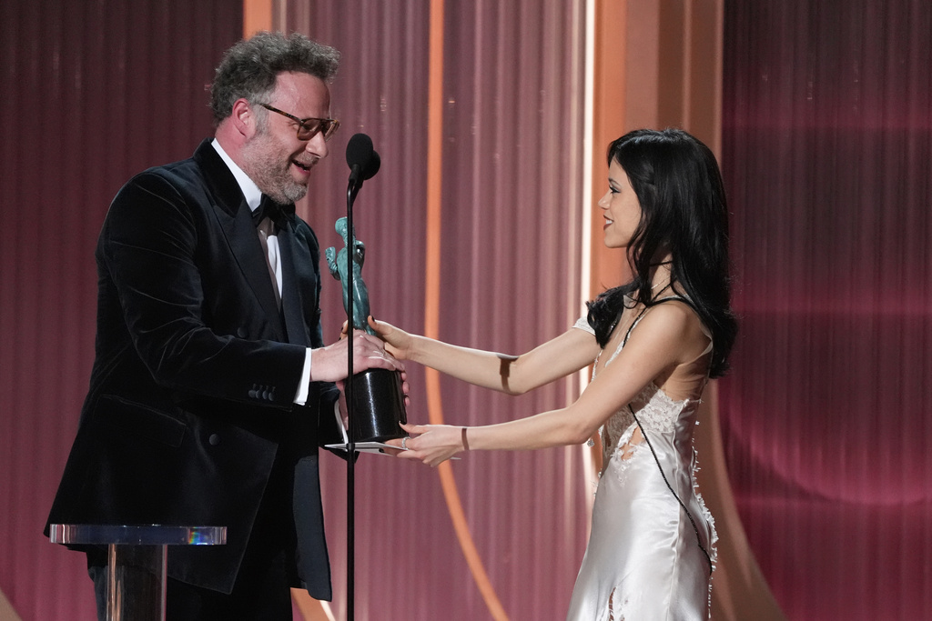 Jenna Ortega, right, presents the award for outstanding performance by a male actor in a comedy series to Seth Rogen, left, for "The Studio" during the 32nd Annual Actor Awards on Sunday, March 1, 2026, at the Shrine Auditorium and Expo Hall in Los Angeles. (AP Photo/Chris Pizzello)
