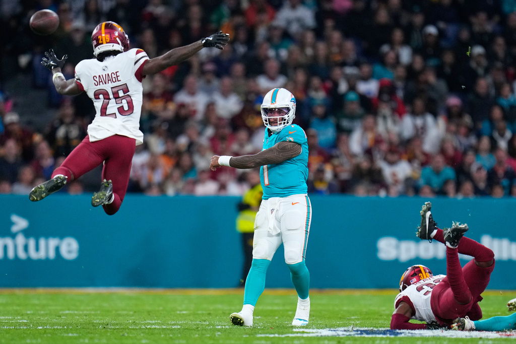 Washington Commanders safety Darnell Savage (25) tries to block a pass from Miami Dolphins quarterback Tua Tagovailoa (1) during the second half of an NFL football game between the Washington Commanders and the Miami Dolphins in Madrid, Spain, Sunday, Nov. 16, 2025. (AP Photo/Manu Fernandez)