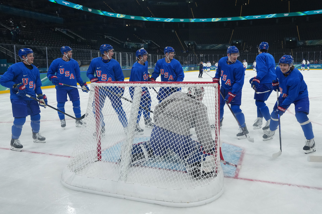 Members of the United States men's ice hockey team including Brady Tkachuk, third from right, Auston Matthews, second from right, and United States' Jack Hughes, right, gather around the net during men's ice hockey practice at the 2026 Winter Olympics, in Milan, Italy, Sunday, Feb. 8, 2026. (AP Photo/Carolyn Kaster)