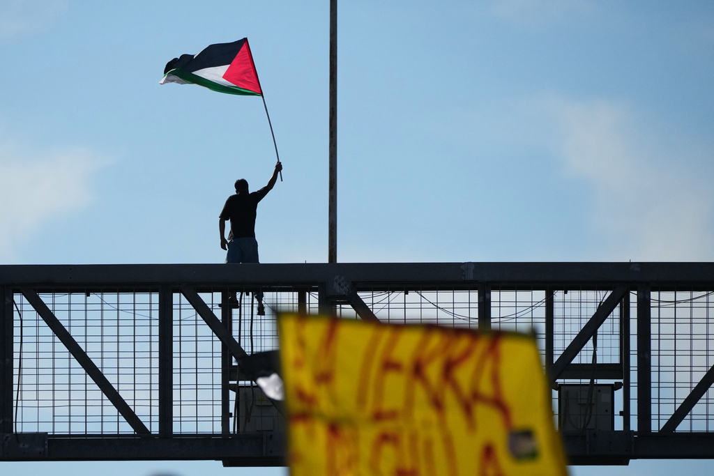 A pro-Palestinian demonstrator protests along the Rome's ring road as they gather for a national general strike called by different unions to protest against the situation in Gaza two days after Israeli forces intercepted a Gaza-bound aid flotilla in the Mediterranean Sea, in Rome, Friday, Oct. 3, 2025. (AP Photo/Alessandra Tarantino)