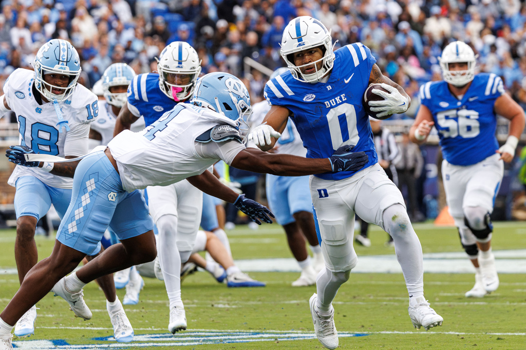 Duke's CJ Campbell (0) carries the ball as North Carolina's Jalon Thompson (4) attempts a tackle during the first half of an NCAA college football game in Durham, N.C., Saturday, Oct. 17, 2026. (AP Photo/Ben McKeown)