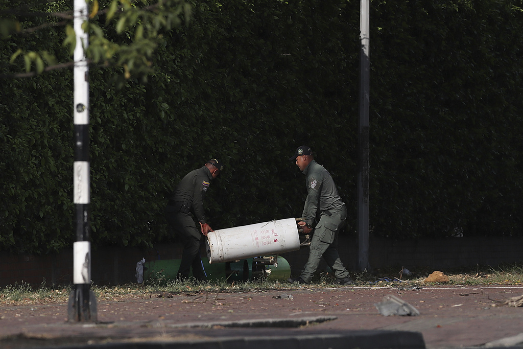 Security forces inspect the site of a bomb explosion outside an Air Force base in Cali, Colombia, Thursday, Aug. 21, 2025. (AP Photo/Santiago Saldarriaga)