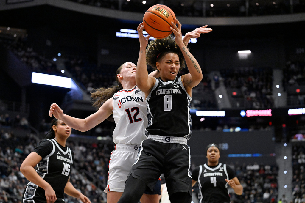 Georgetown guard Khadee Hession (8) grabs a rebound over UConn guard Ashlynn Shade (12) in the first half of an NCAA college basketball game, Thursday, Feb. 26, 2026, in Hartford, Conn. (AP Photo/Jessica Hill)