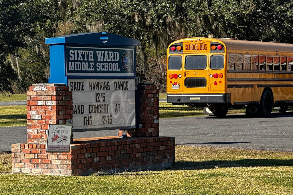 A school bus carries children at the end of a school day at Sixth Ward Middle School in Thibodaux, La., on Dec, 11, 2025. (AP Photo/Stephen Smith)