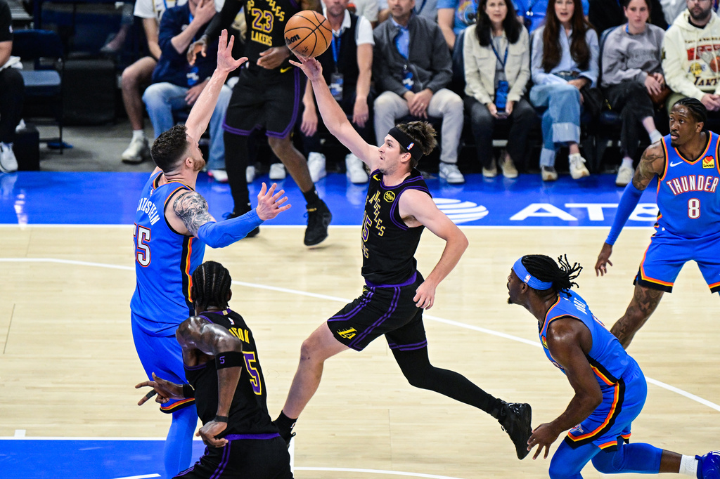 Los Angeles Lakers guard Austin Reaves (15) pass against Oklahoma City Thunder center/forward Isaiah Hartenstein (55) during the first half of an NBA basketball game Thursday, April. 2, 2026, in Oklahoma City. (AP Photo/Gerald Leong)