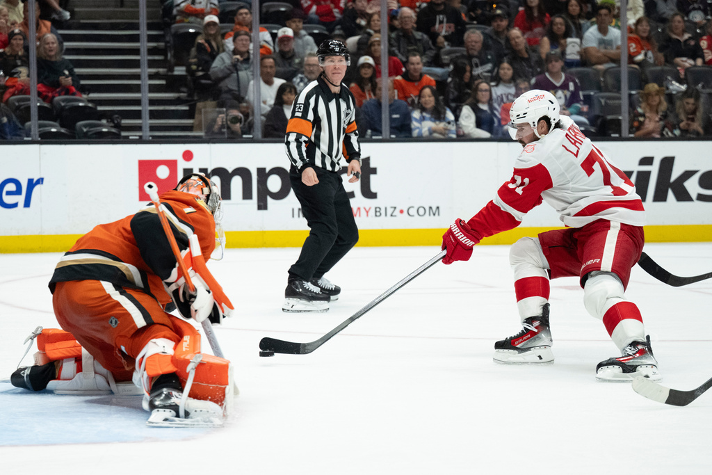 Detroit Red Wings center Dylan Larkin, right, shoots as Anaheim Ducks goaltender Lukas Dostal (1) defends during the second period of an NHL hockey game, Friday, Oct. 31, 2025, in Anaheim, Calif. (AP Photo/Kyusung Gong)