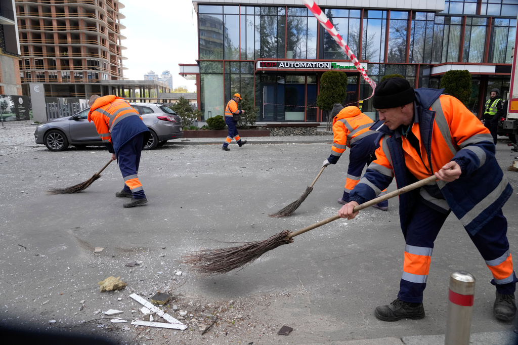 Municipal workers clear debris after a Russian drone attack in Kyiv, Ukraine, Tuesday, April 28, 2026. (AP Photo/Efrem Lukatsky)