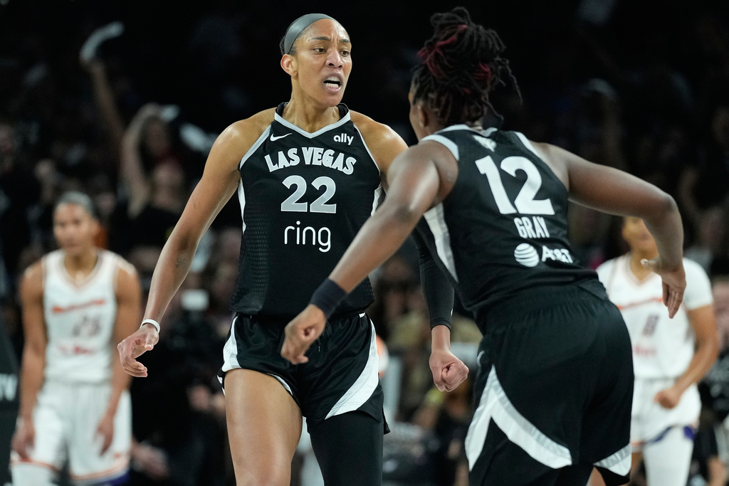 Las Vegas Aces center A'ja Wilson (22) and guard Chelsea Gray (12) celebrate during the first half in Game 2 of the WNBA basketball finals against the Phoenix Mercury, Sunday, Oct. 5, 2025, in Las Vegas. (AP Photo/John Locher)